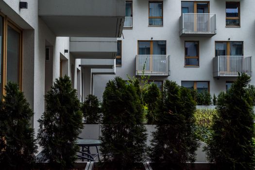 Modern apartment building with balconies and lush greenery for an urban lifestyle vibe.