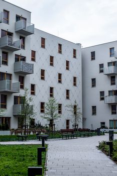 Contemporary white urban apartment buildings with balconies and greenery.