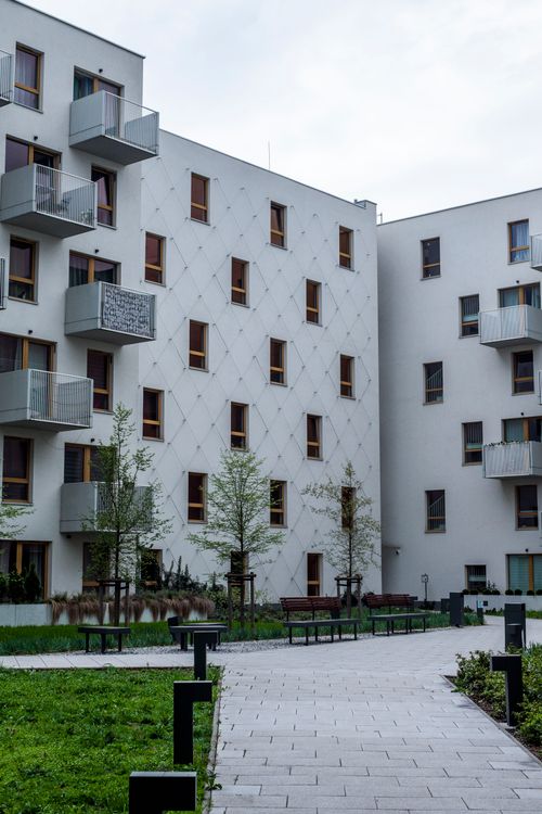 Free Contemporary white urban apartment buildings with balconies and greenery. Stock Photo