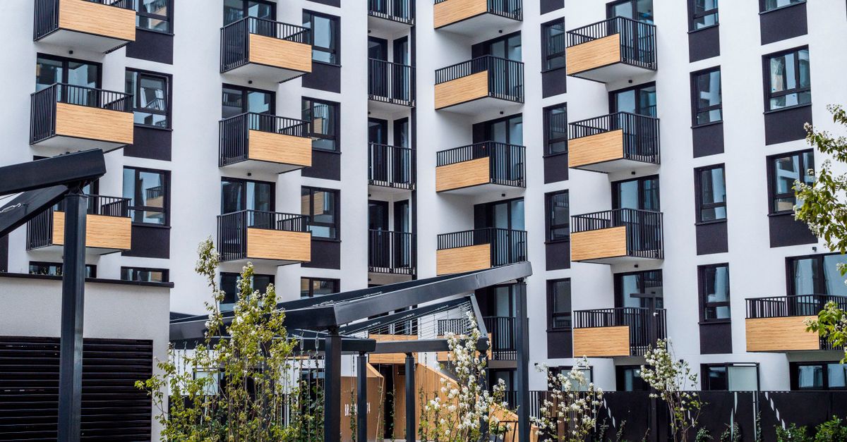 Contemporary apartment building with balconies and garden in spring.