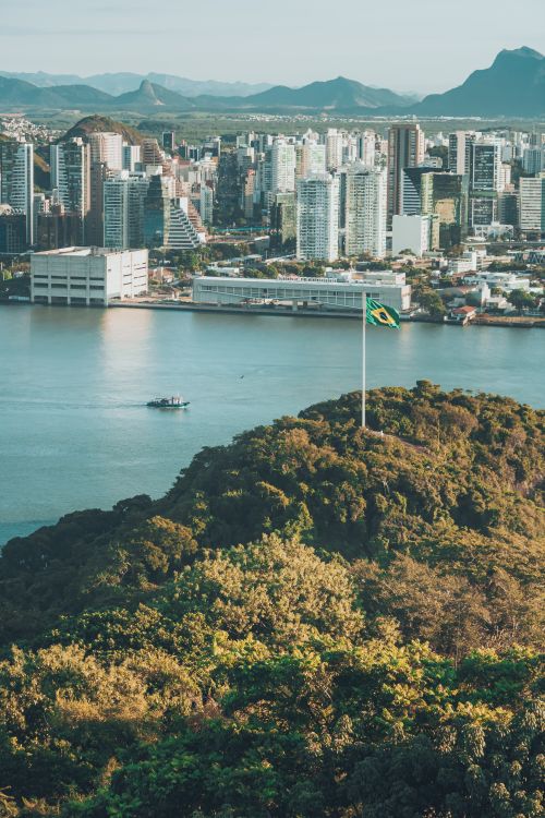 Free Scenic aerial view of Rio de Janeiro with Brazilian flag and city skyline across the bay. Stock Photo