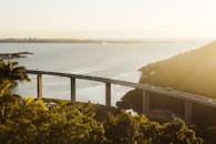 一个阳光明媚的桥梁位于宁静的沿海景观中，展现出壮丽的景色，是理想的旅行画面