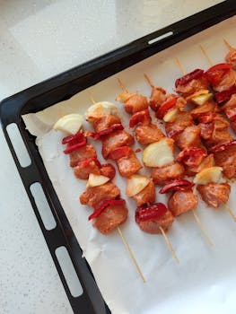 Delicious skewers of marinated chicken, red pepper, and onions ready to grill.