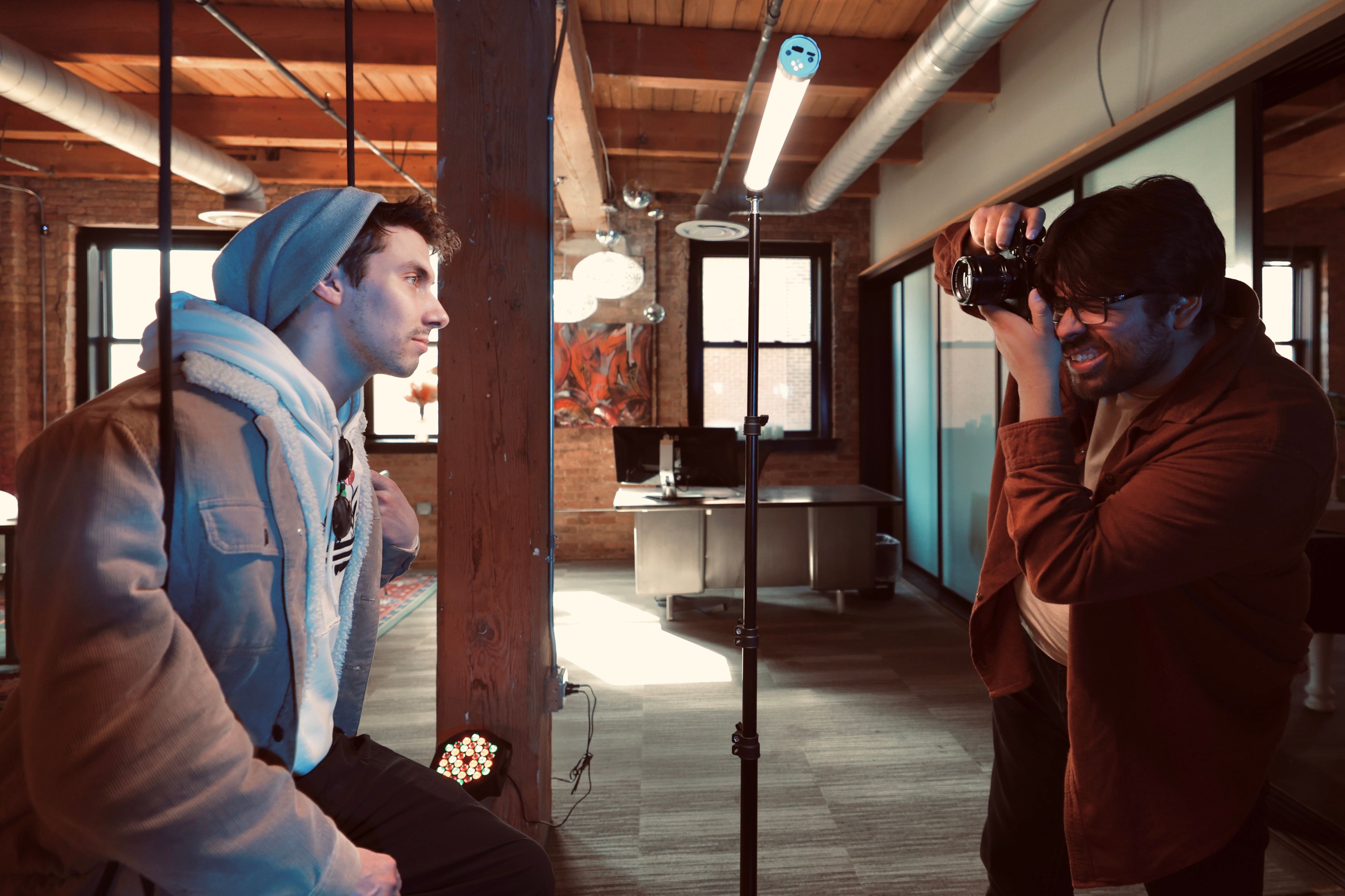 A candid moment of a photographer taking a portrait in a modern, stylish urban studio setting.