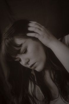 Moody, sepia-tone portrait capturing a woman's thoughtful expression.
