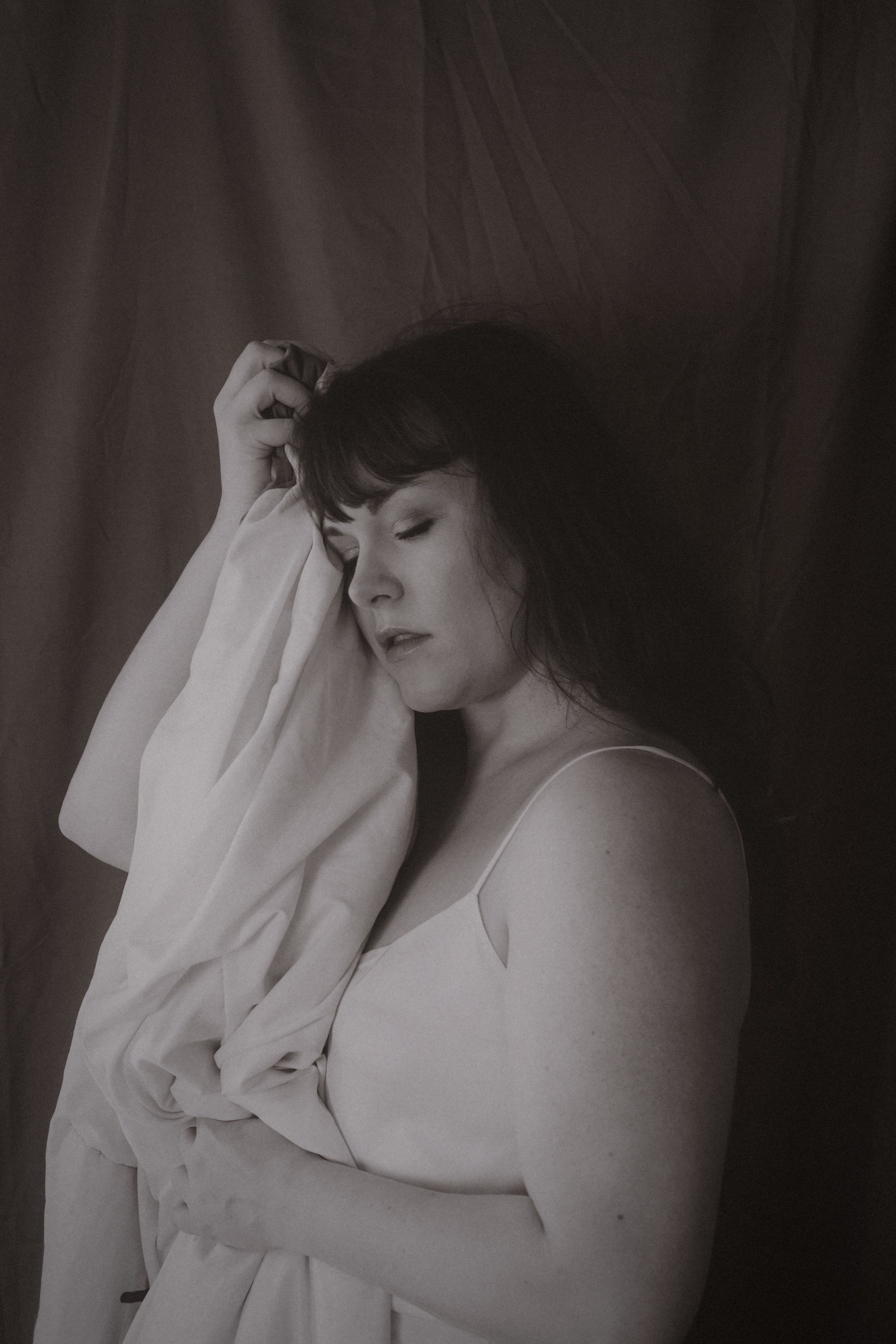A serene and emotional portrait of a woman in sepia tone, capturing vintage aesthetics.