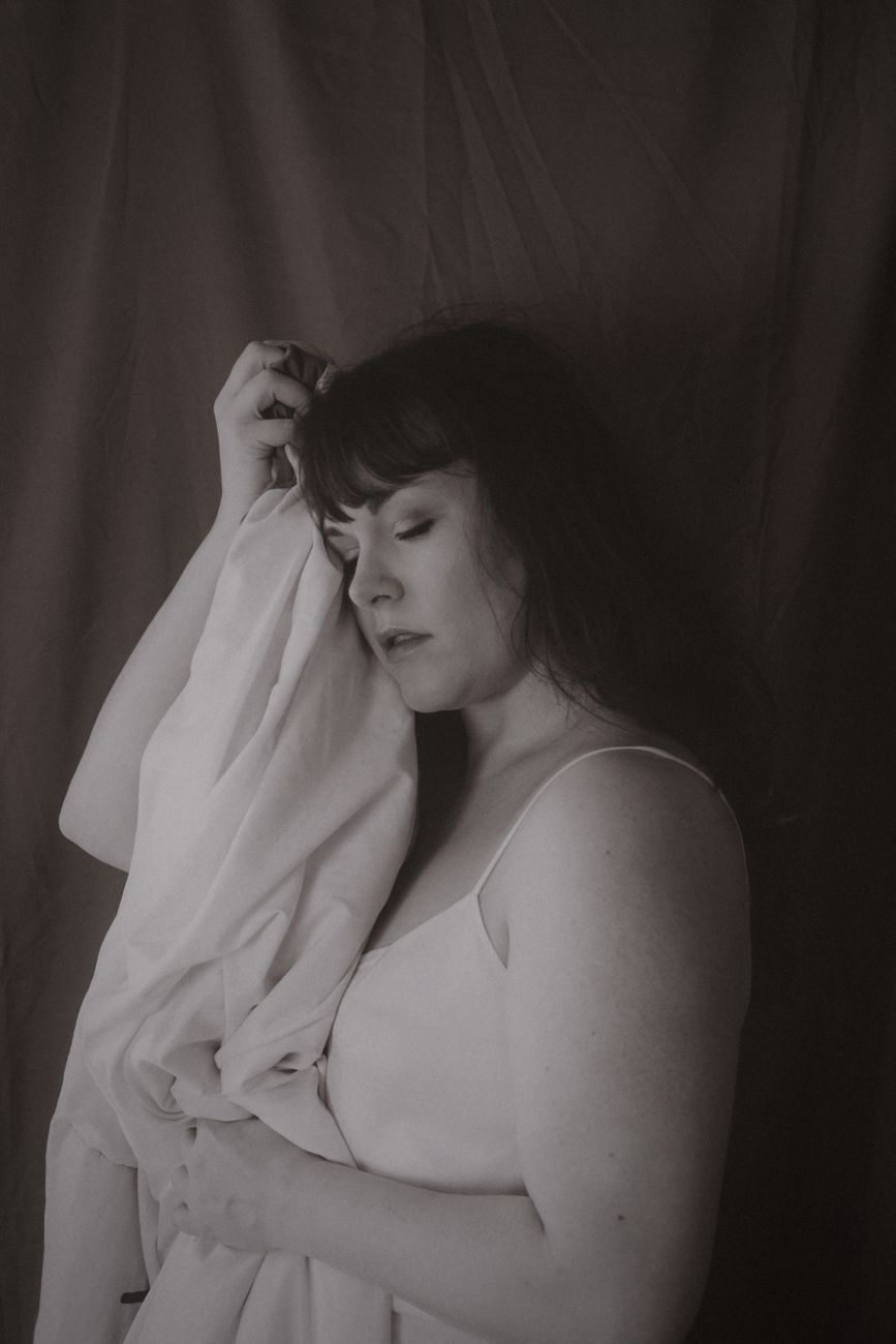 A serene and emotional portrait of a woman in sepia tone, capturing vintage aesthetics.