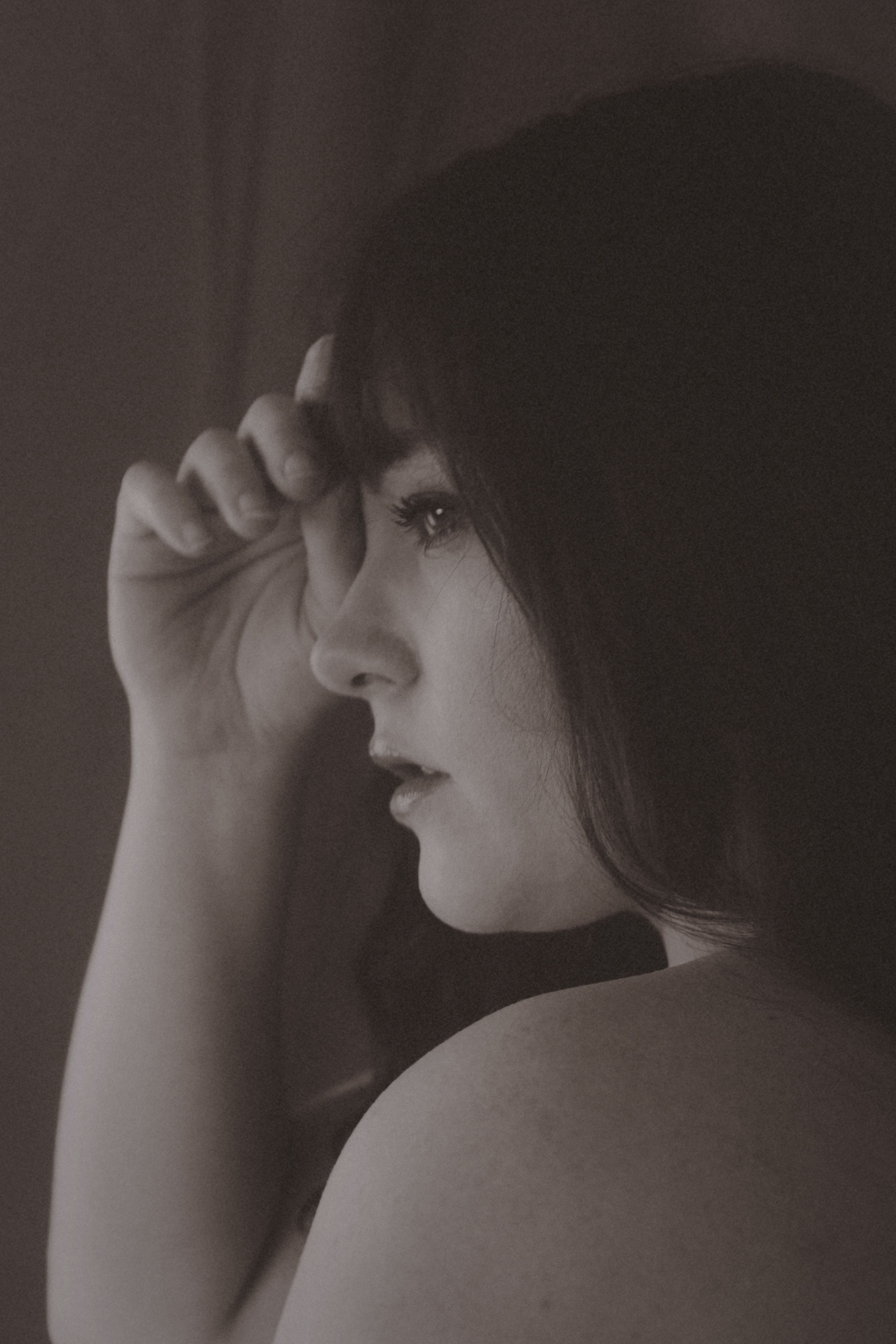 Vintage-inspired sepia portrait capturing a young woman's thoughtful expression.