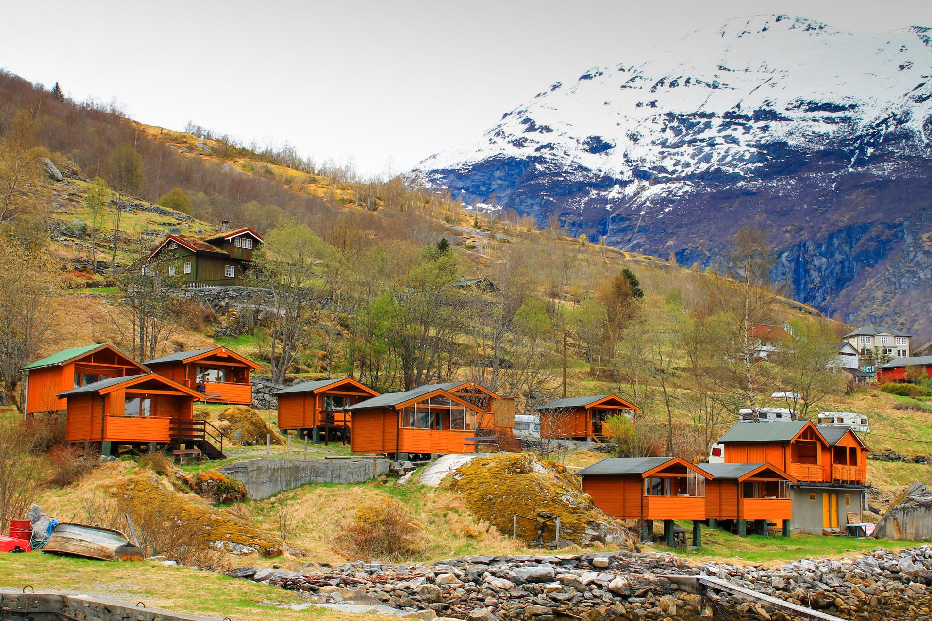 A wooden barn in a fjord village with mountain backdrop