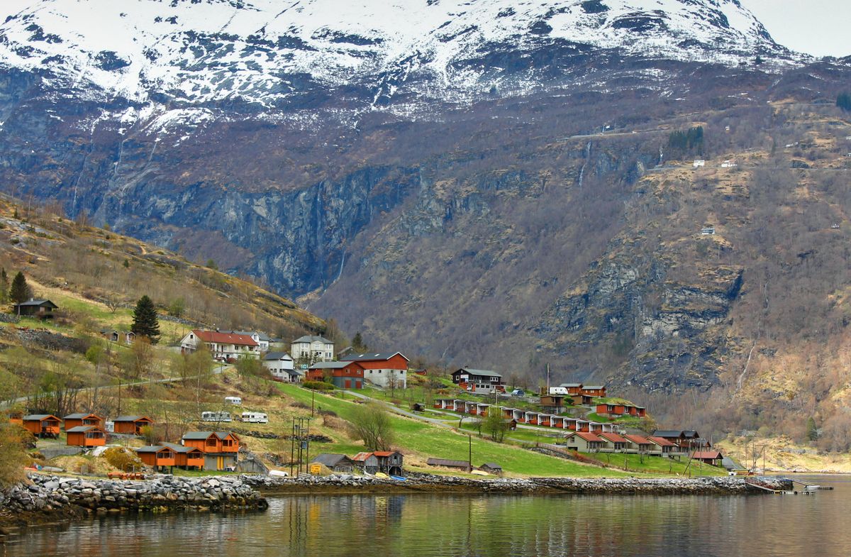 Norwegian fjord village set between snowy mountains with tranquil water