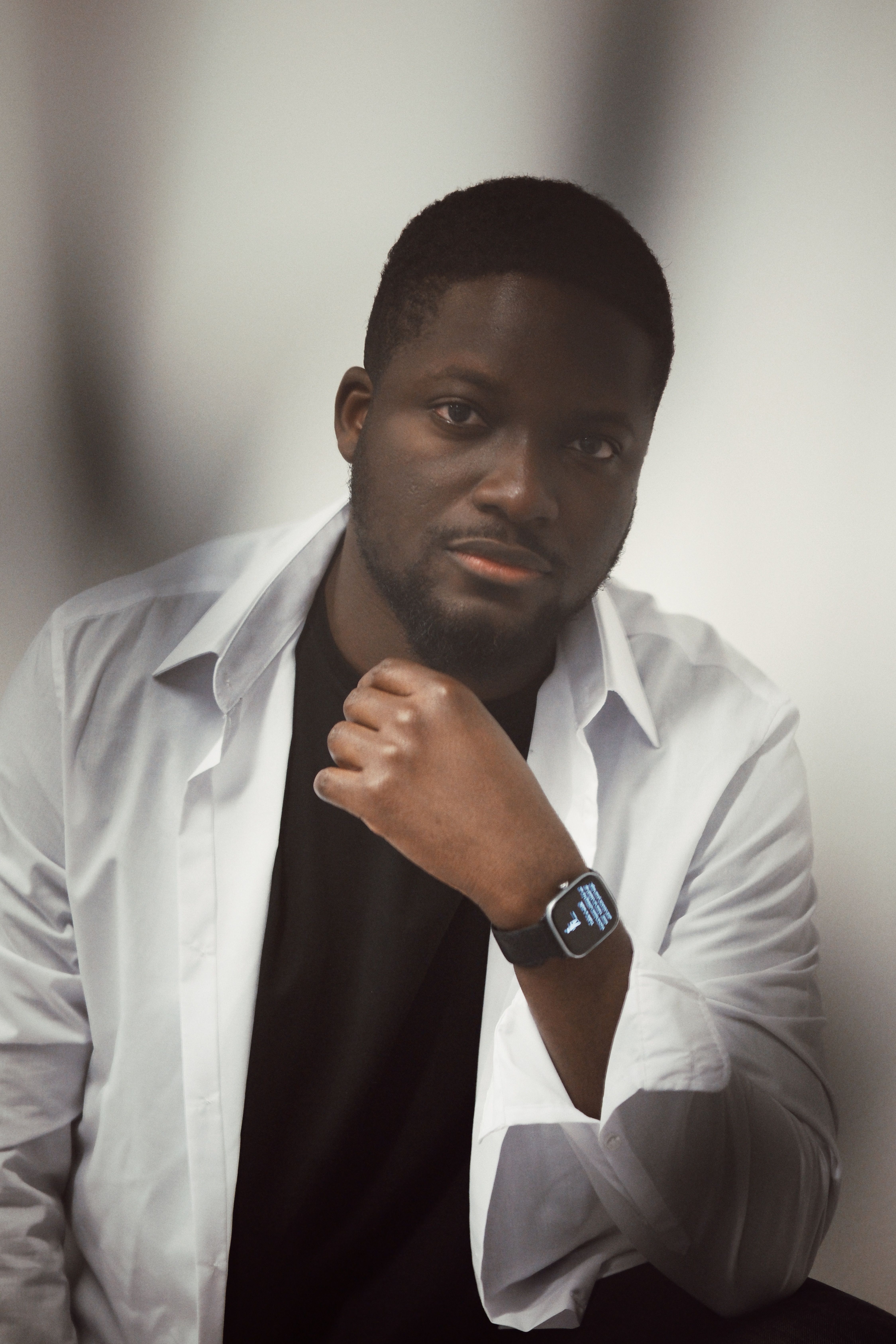 Stylish portrait of a man with a smartwatch and white shirt, showcasing modern fashion.