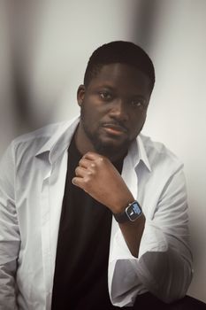 Stylish portrait of a man with a smartwatch and white shirt, showcasing modern fashion.