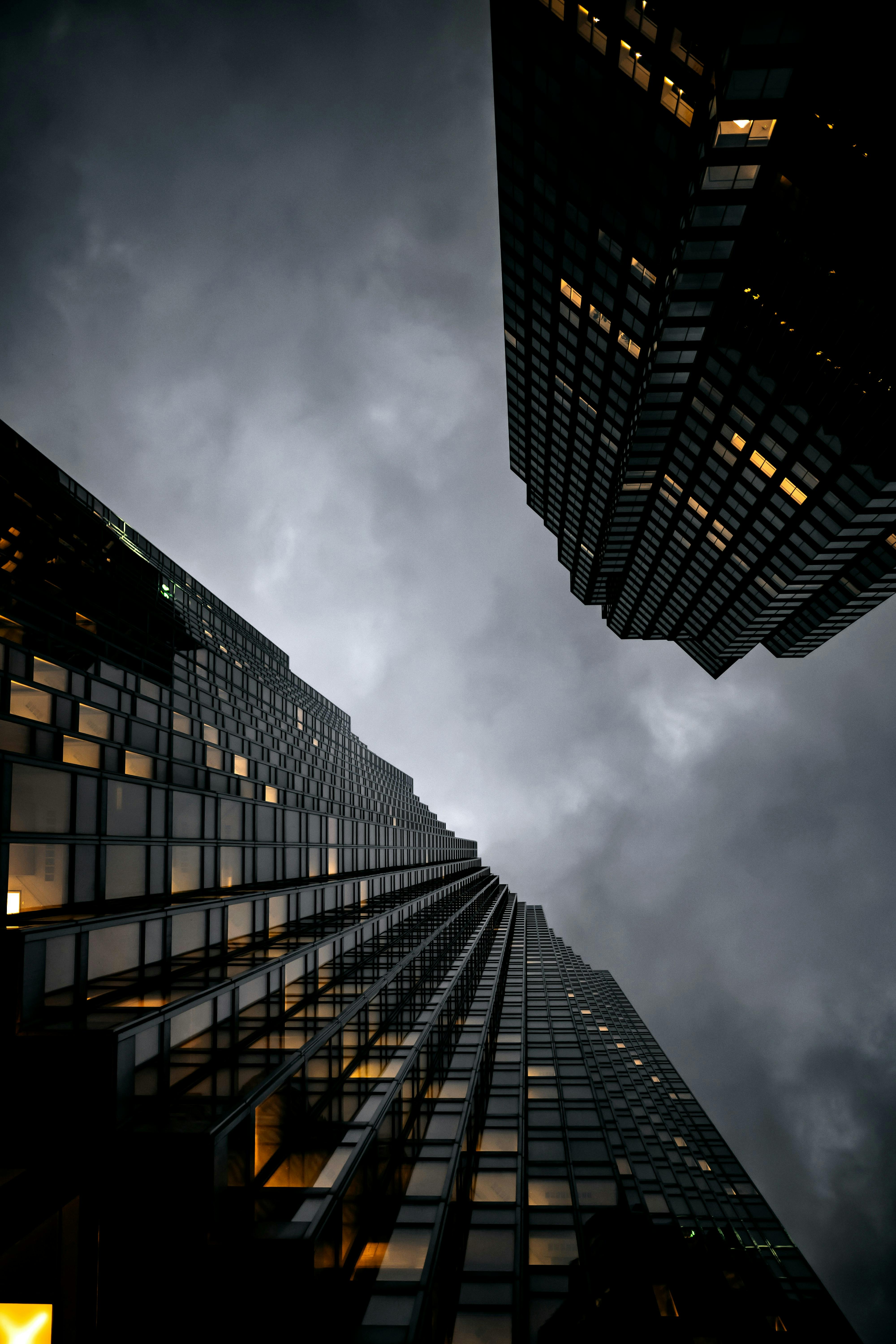 Toronto skyscrapers loom under a dramatic, overcast sky, showcasing modern architecture.