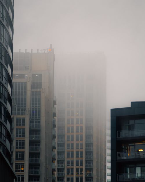 Free Moody view of Toronto skyscrapers shrouded in fog, capturing architectural beauty. Stock Photo