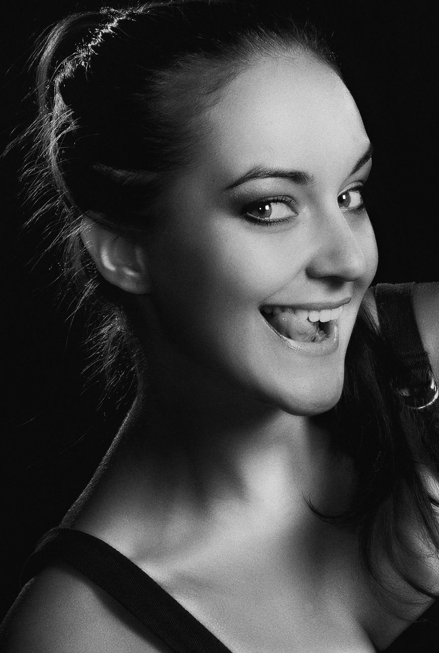 Charming black and white portrait of a smiling woman in Kyiv studio.