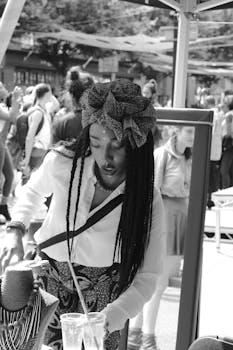 一张黑白照片中，一位时尚女性身处繁华的街头市场