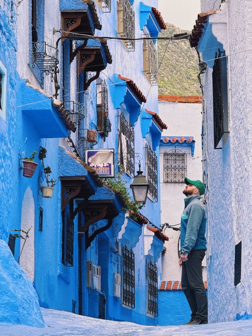 Free A man admires the vibrant blue buildings in Chefchaouen, Morocco. Stock Photo