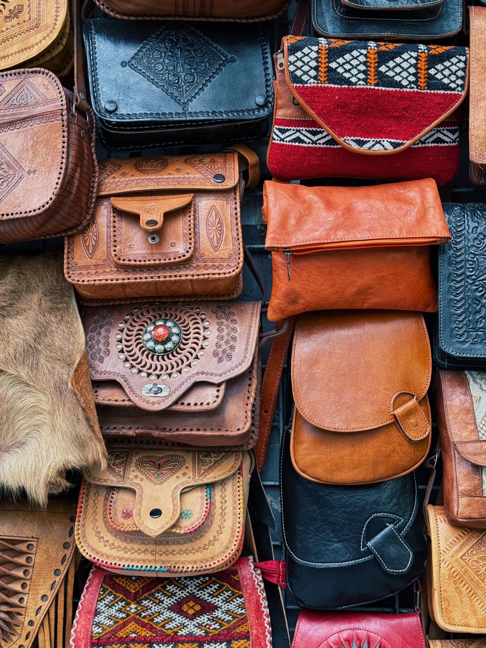 Hand-built leather bags set out together, each one slightly different