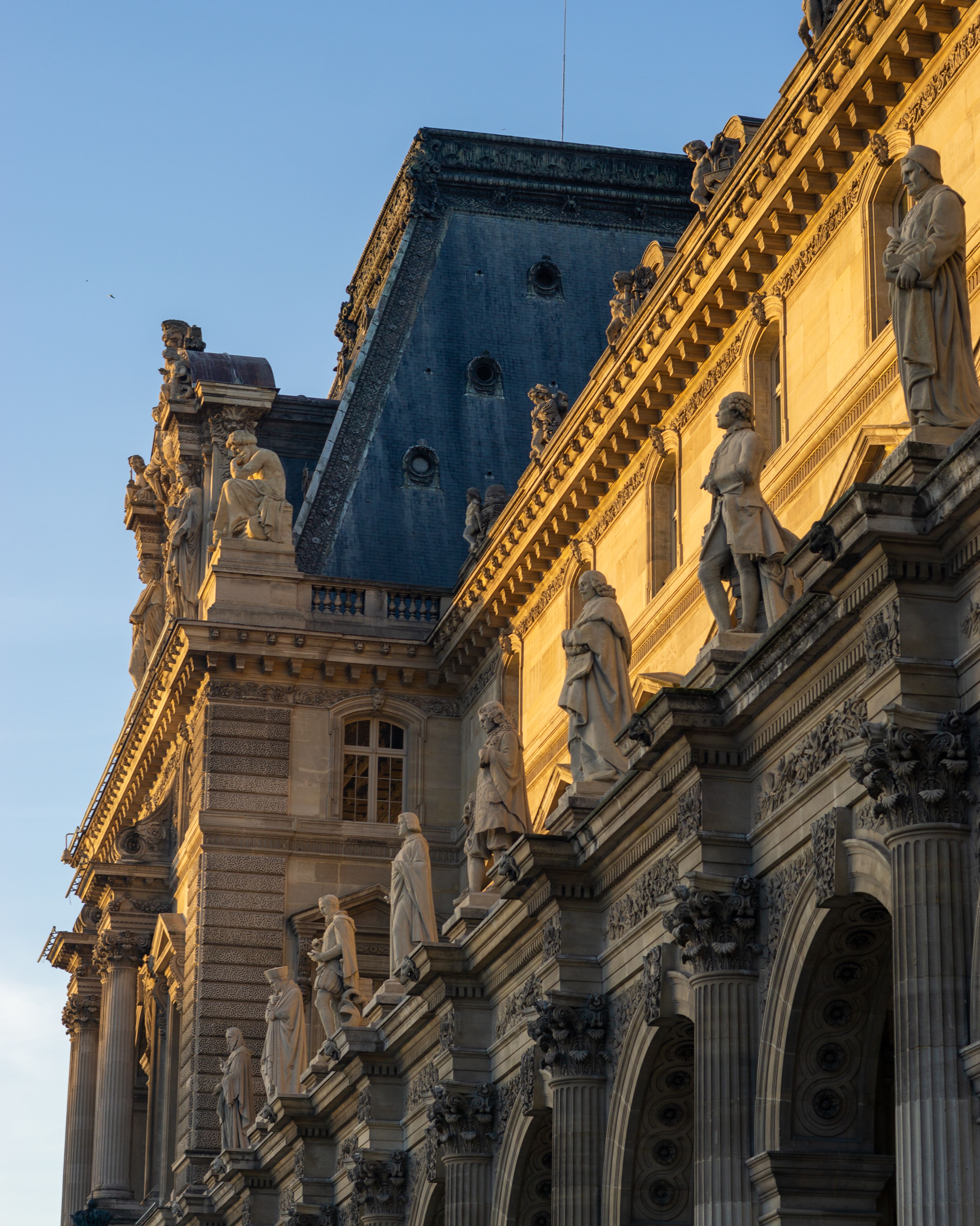 Sunlit Facade of Louvre Museum in Paris · Free Stock Photo