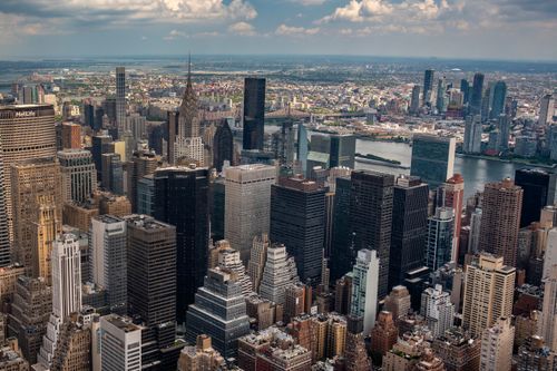 Free A breathtaking aerial view of New York City showcasing iconic skyscrapers under a cloudy sky. Stock Photo