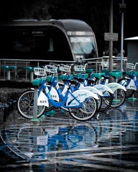 Urban bike sharing station in Kayseri, Türkiye after rain, reflecting wet pavement and city life.