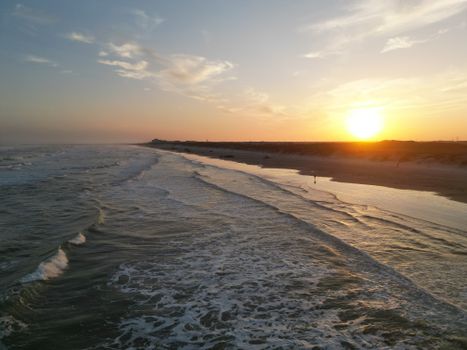Breathtaking view of Corpus Christi beach at sunset, showcasing serene waves and glowing horizon.
