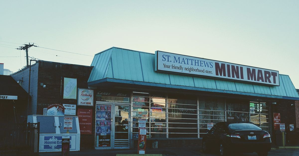 View of St. Matthews Mini Mart with a car parked outside in an urban setting.