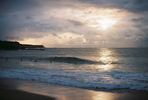 Free Peaceful sunrise over Coogee Beach in NSW with gentle waves and cloudy skies. Stock Photo