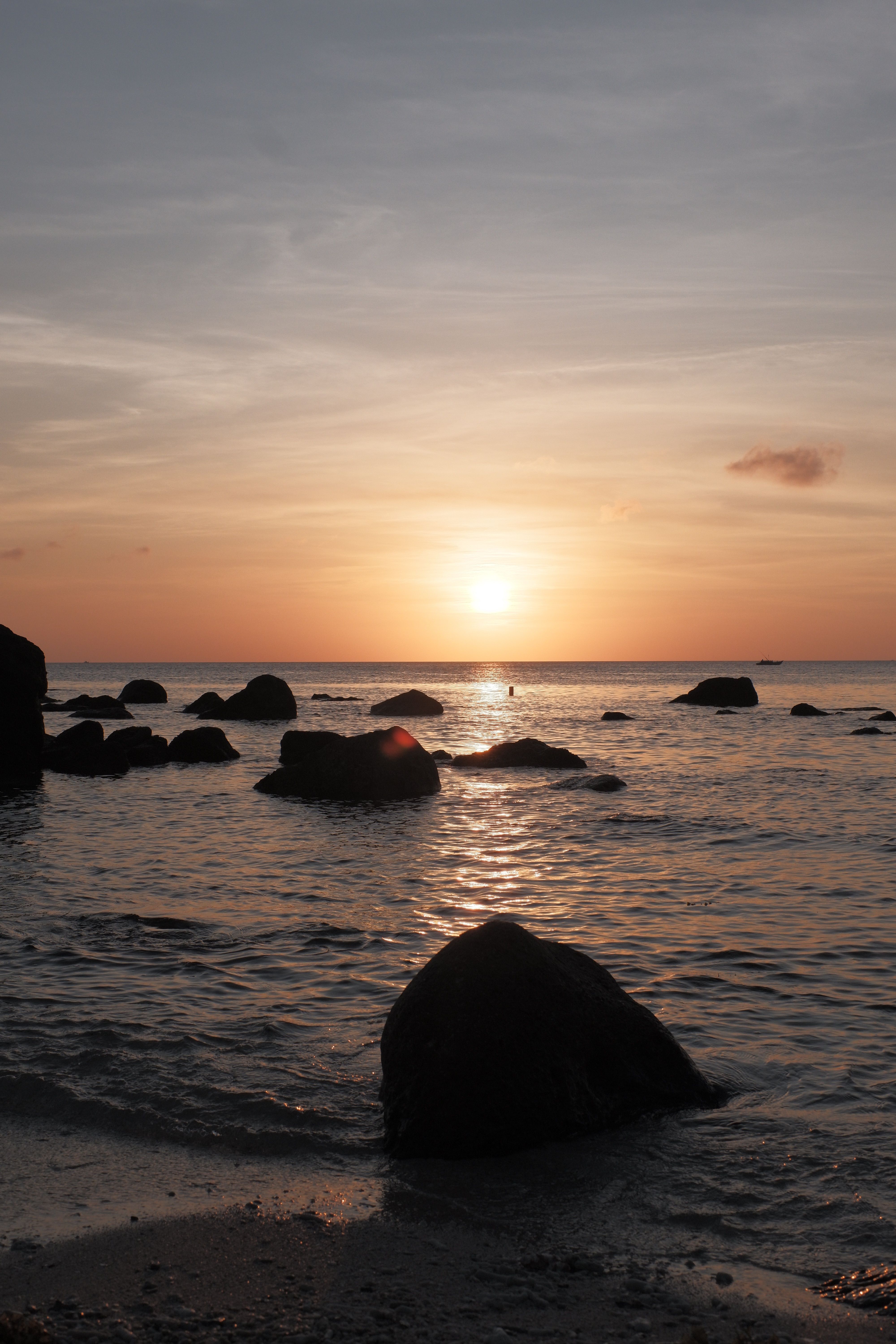 Serene Beach Sunset with Rocks at Dusk · Free Stock Photo