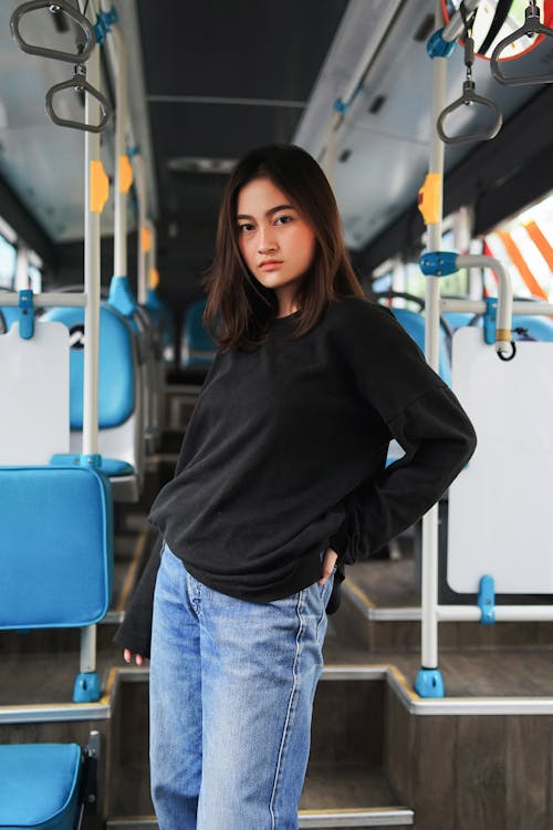 Woman in Black Sweater and Blue Jeans Standing Inside Vehicle