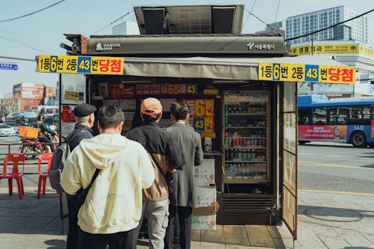 A group of people waits in line at a kiosk in bustling Seoul, capturing a slice of urban life.
