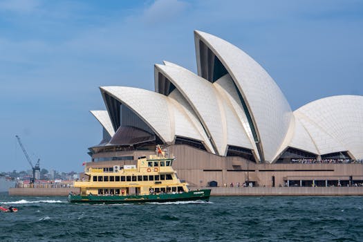 Vista dell'Opera House di Sydney con un traghetto in transito nel porto di Sydney, Australia.