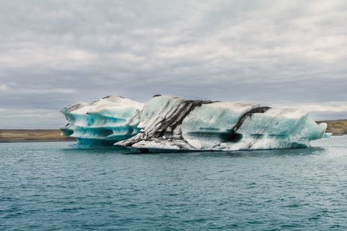 Free Serene iceberg floating in the blue waters of Iceland, capturing nature's cold beauty. Stock Photo