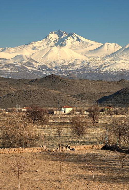 Free Stunning view of snowcapped mountains and rural farmland under clear skies. Stock Photo