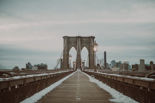 Brooklyn Bridge view in winter with New York City skyline in the background.