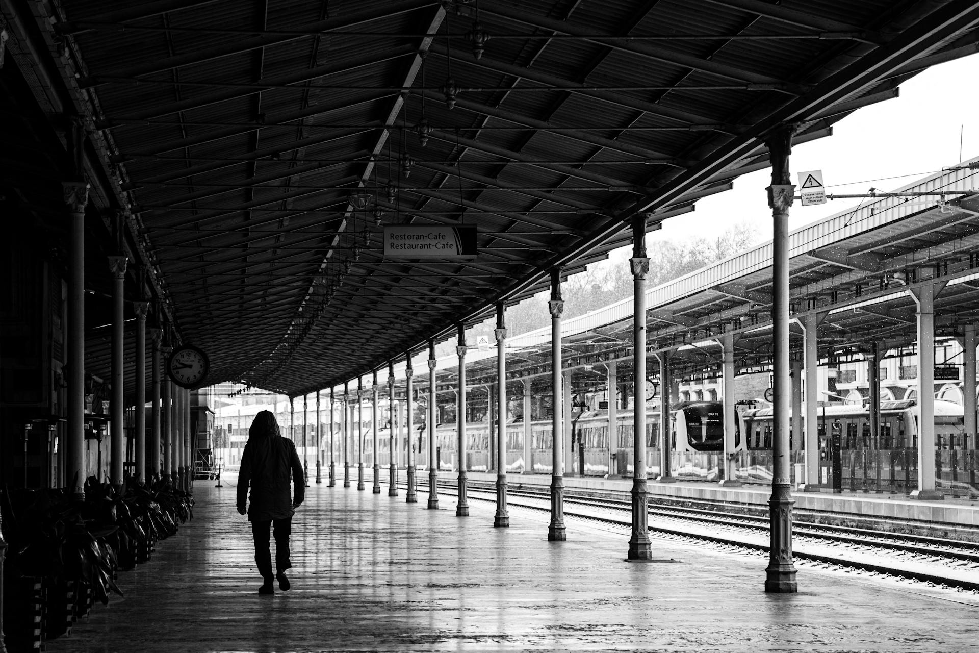 Silhouette of a person walking in an Istanbul train station, captured in black and white.