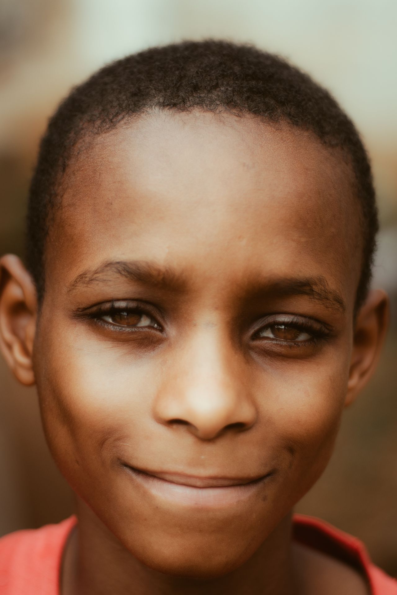 Smiling young Nigerian boy outdoors with bright eyes