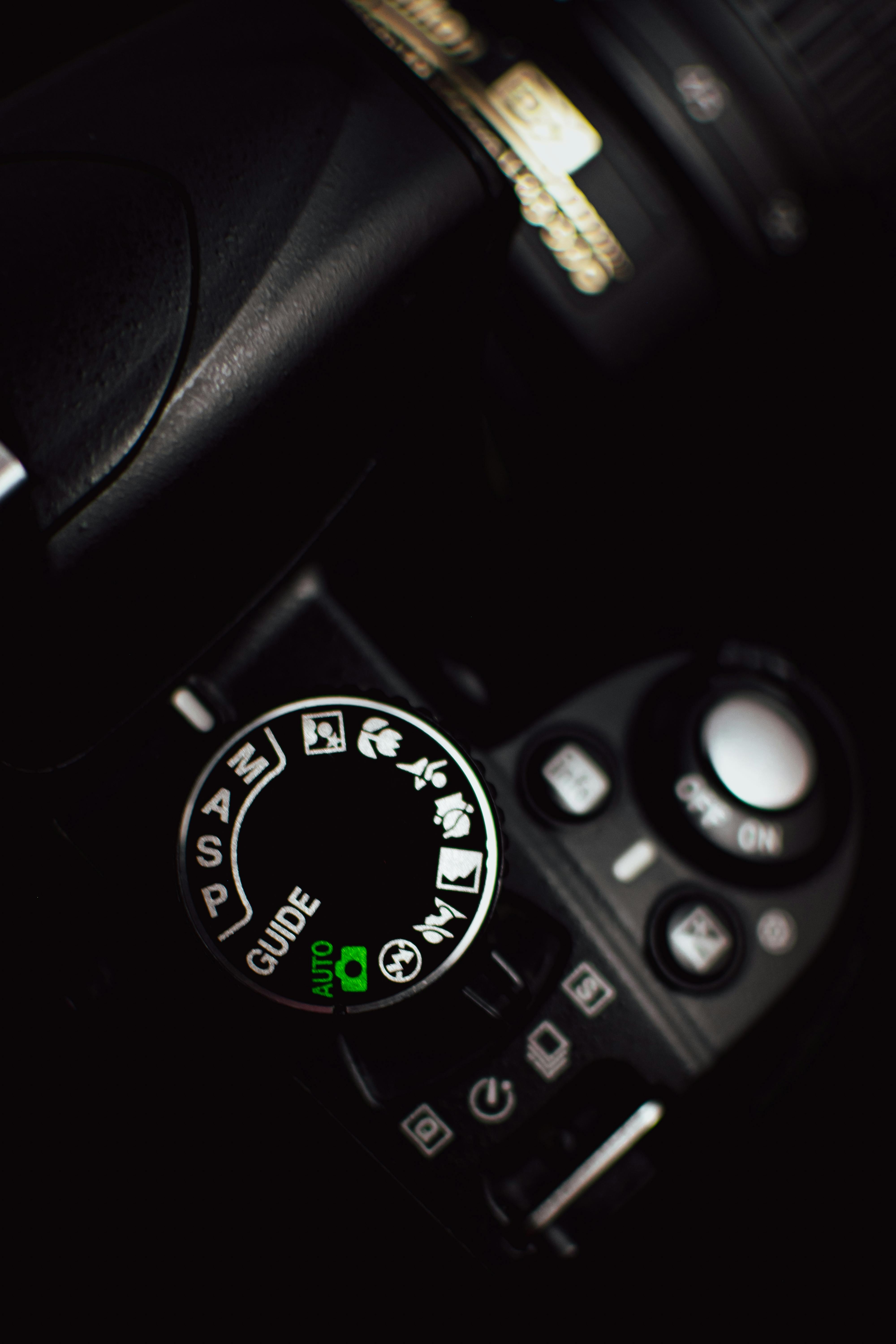 gratis Gedetailleerde weergave van de modusknop van een DSLR-camera met de focus op automatische instellingen, tegen een donkere achtergrond. Stockfoto