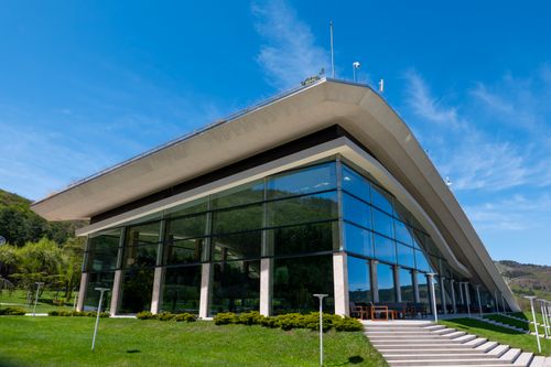 Free Contemporary architecture with glass facade and lush greenery in T'bilisi, Georgia under a bright blue sky. Stock Photo