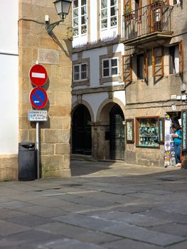 A picturesque street scene in Santiago de Compostela featuring classic stone architecture and signage.