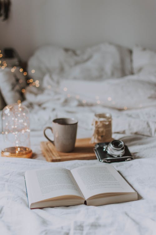 Free Gray Ceramic Mug Near Black and Silver Camera and Open Book Stock Photo