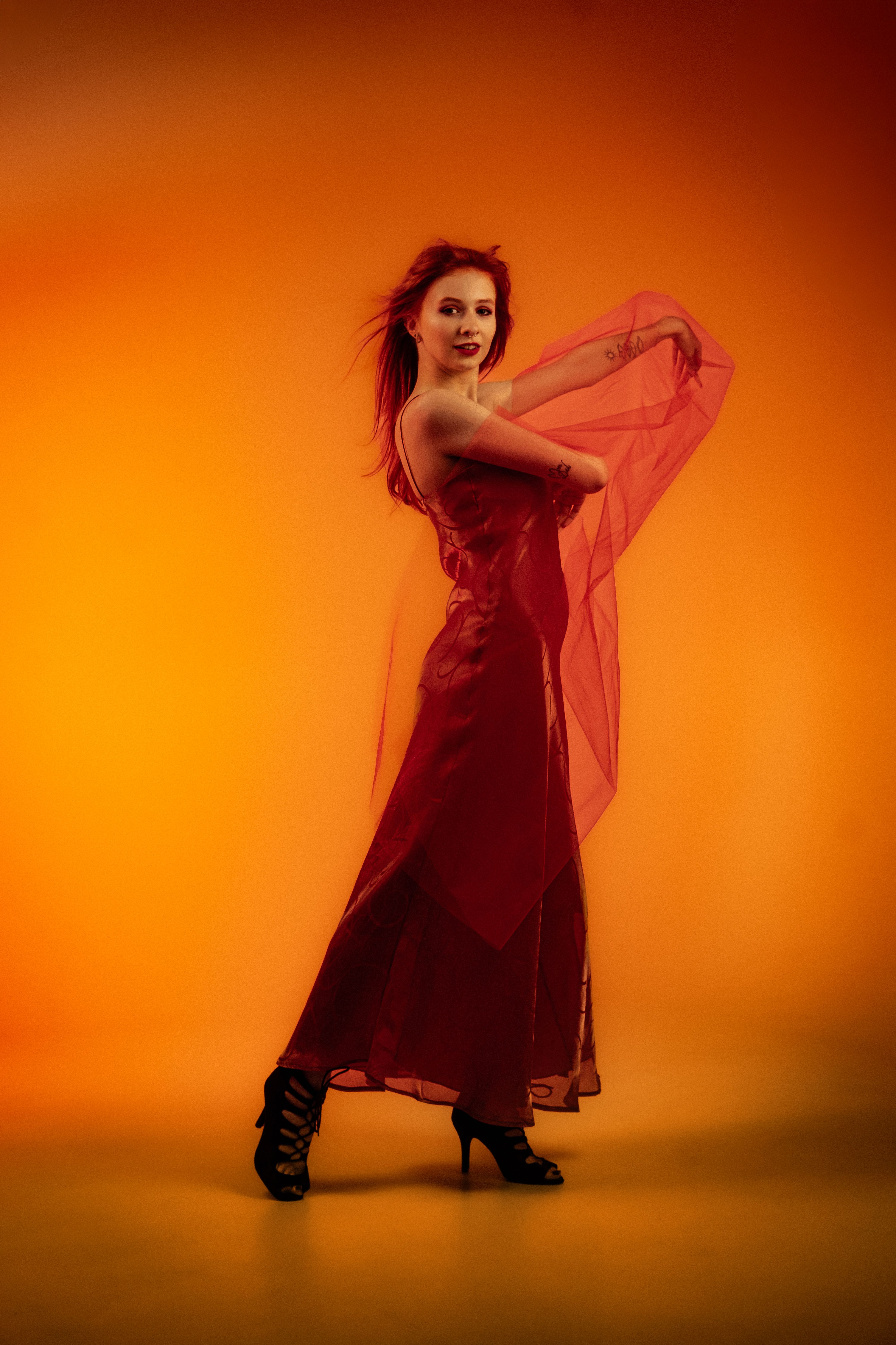 Elegant Woman in Red Dress with Orange Backdrop · Free Stock Photo