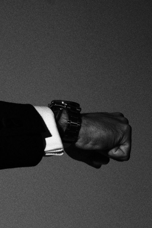 Free Close-up of a businessman's wrist wearing a classic watch and suit, exuding elegance and style. Stock Photo