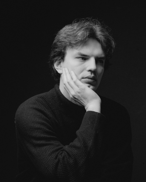 Free Black and white portrait of a man in thoughtful pose against a dark background. Stock Photo