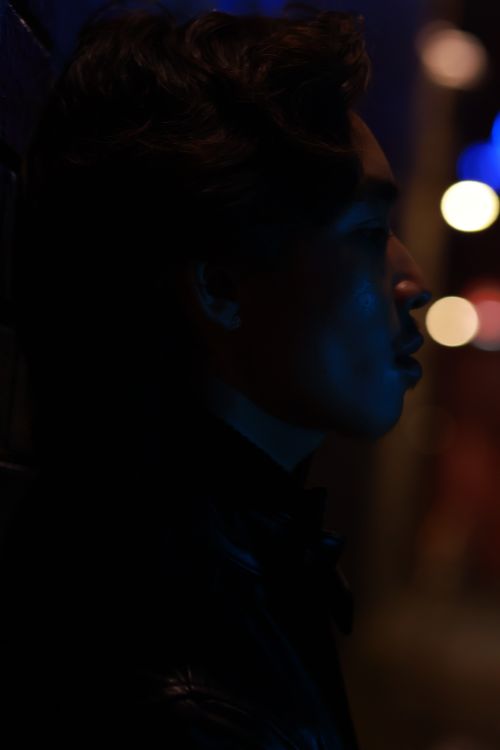 Free Artistic portrait of a young man in neon lighting, capturing a moody city night vibe. Stock Photo