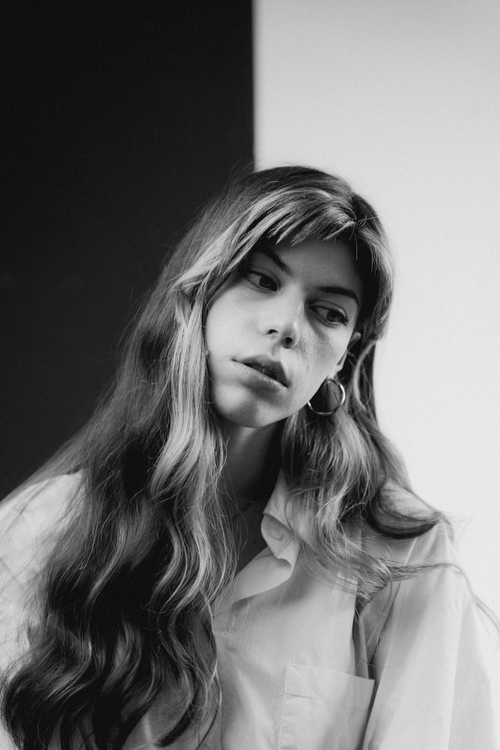 Free Elegant black and white portrait of a woman with long flowing hair and thoughtful expression. Stock Photo