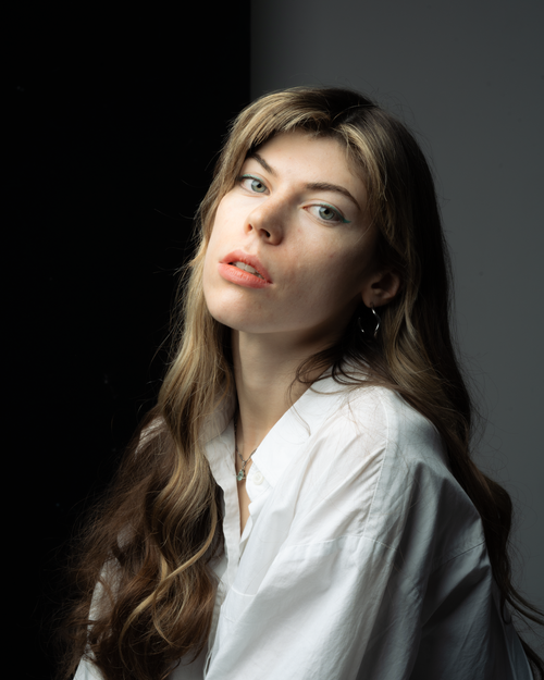 Free Close-up portrait of a woman with long hair wearing a white shirt. Stock Photo
