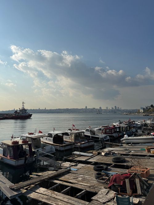 Free Boats docked at a harbor in İstanbul with the city skyline and calm sea in the background. Stock Photo