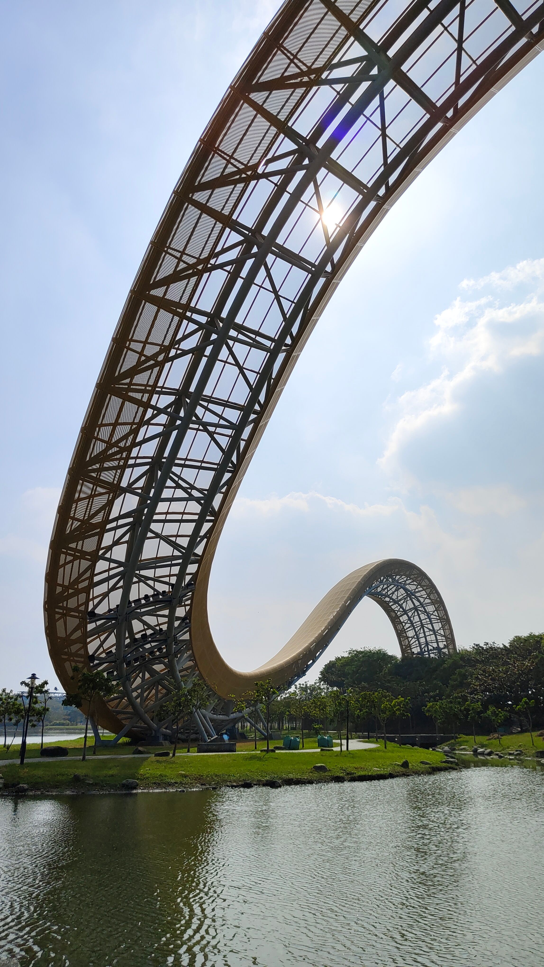 A striking metal sculpture with sweeping curves set against a sunny sky in Tainan, Taiwan.