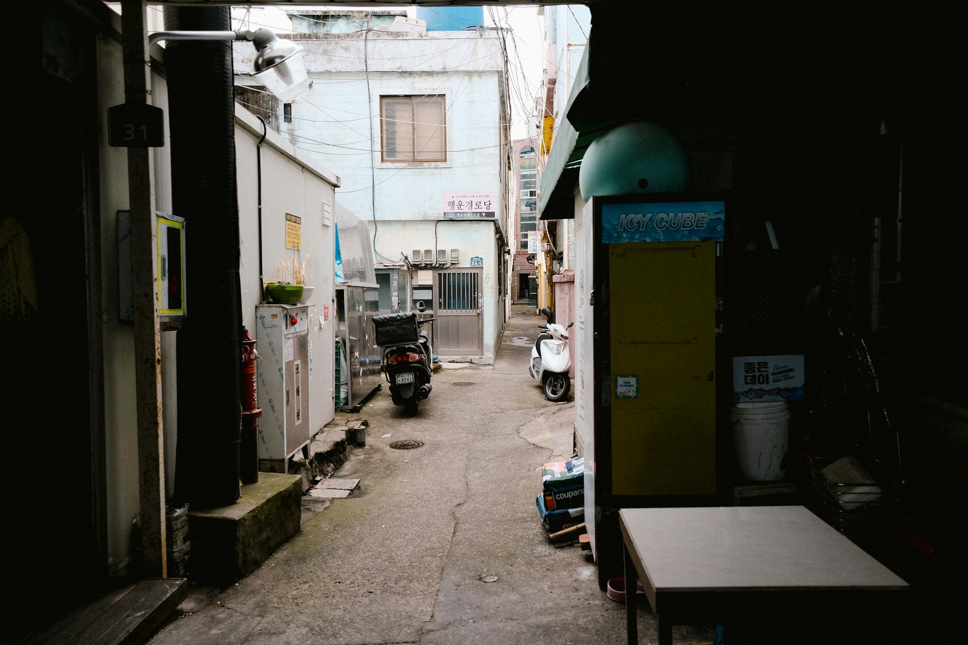 A quiet alleyway in a residential area of Seoul, showcasing everyday urban life and architecture.